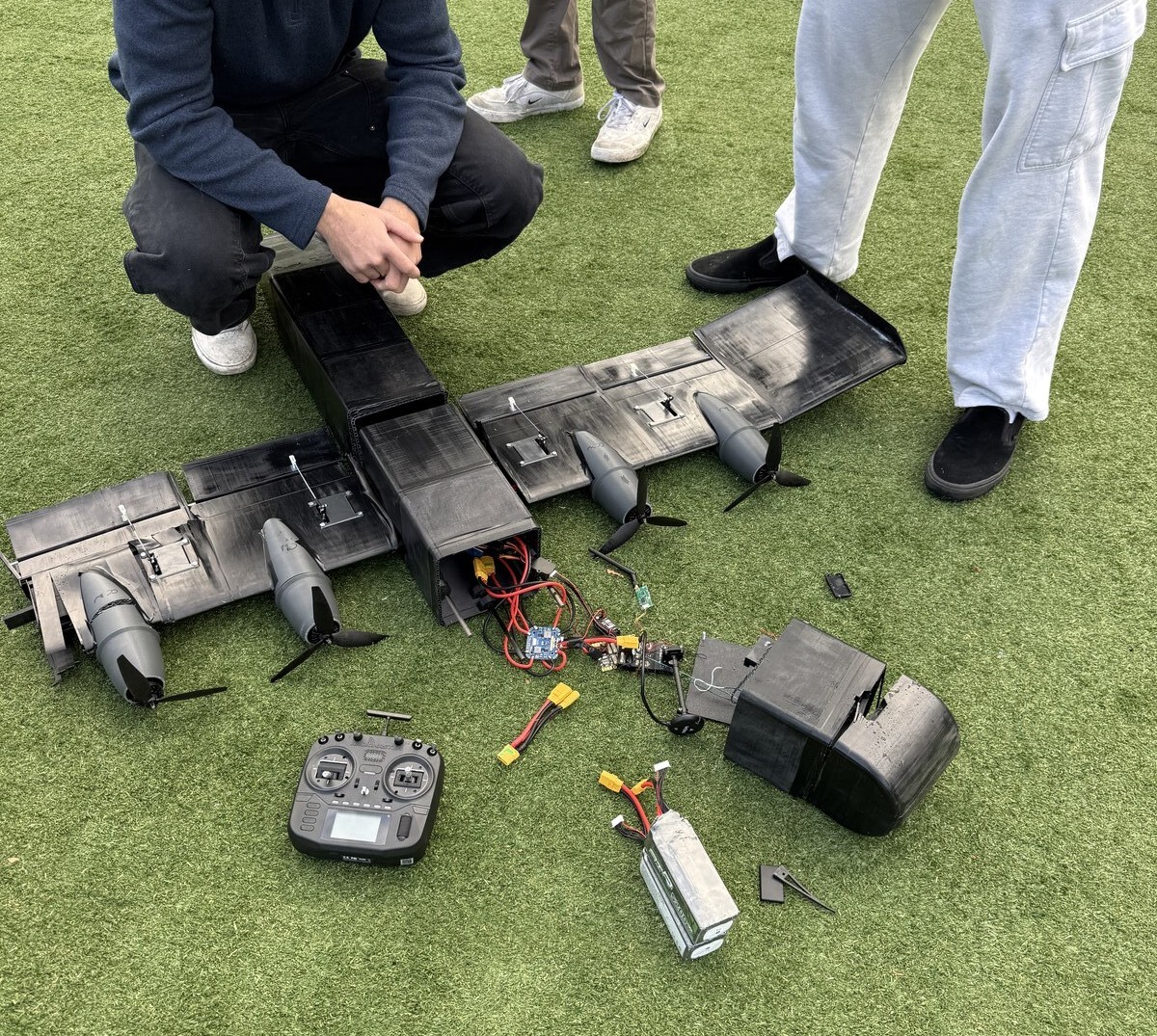 Aftermath of Crash 2: left wing and wingbox destroyed, team kneeling next to the vehicle to assess damage.